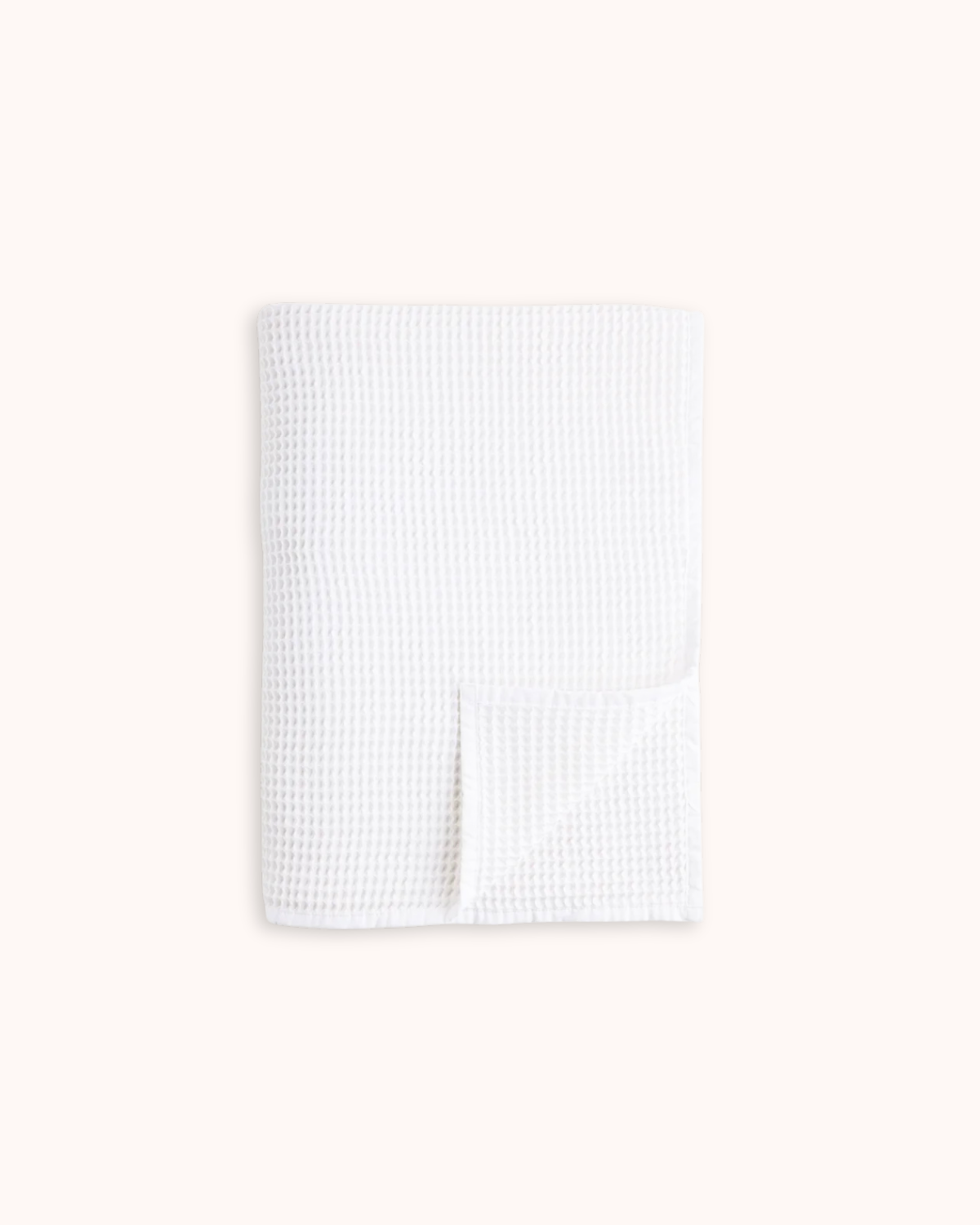 A folded white waffle-weave fabric item, likely a baby blanket or towel, shown on a solid off-white background.