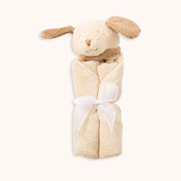 A beige plush bunny-shaped baby wrap or towel with floppy ears, a small stitched face, and a white ribbon tied around the middle, shown on a plain light background.