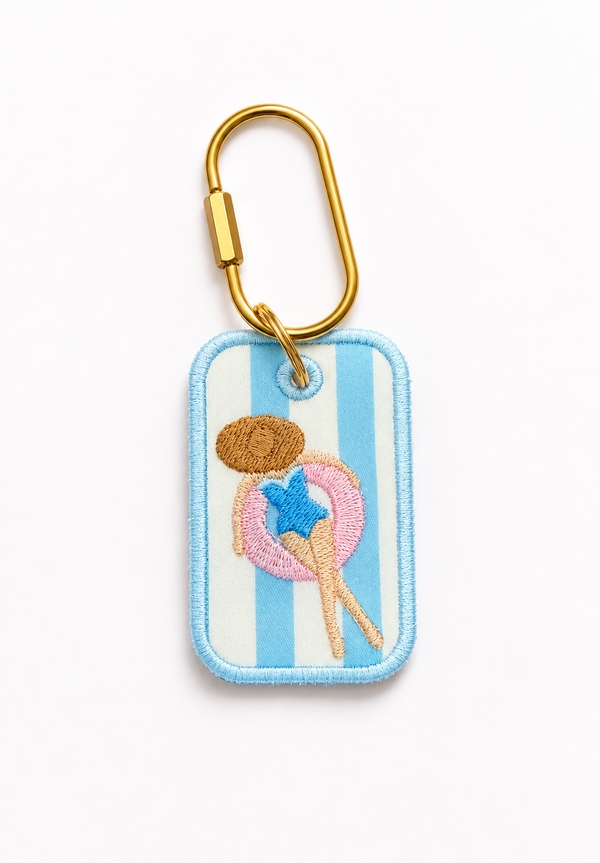 A custom rectangular embroidered patch with a gold carabiner attached, featuring a light blue and white striped background with a central embroidered ice cream cone motif in pink, blue, and brown.